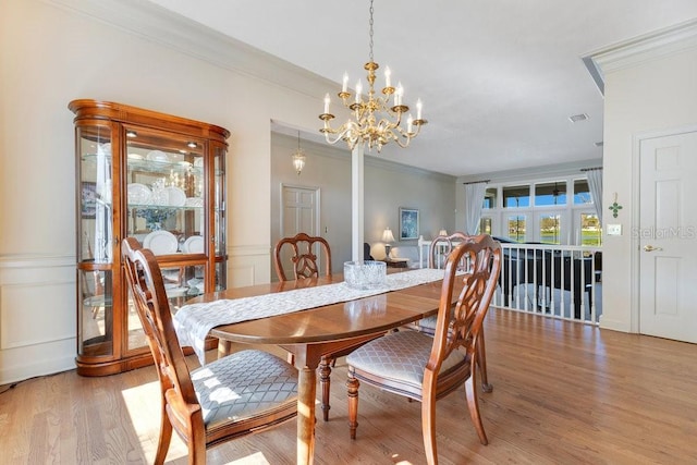 dining room featuring a notable chandelier, crown molding, and light hardwood / wood-style floors