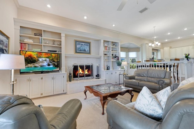 living room with ceiling fan with notable chandelier and crown molding