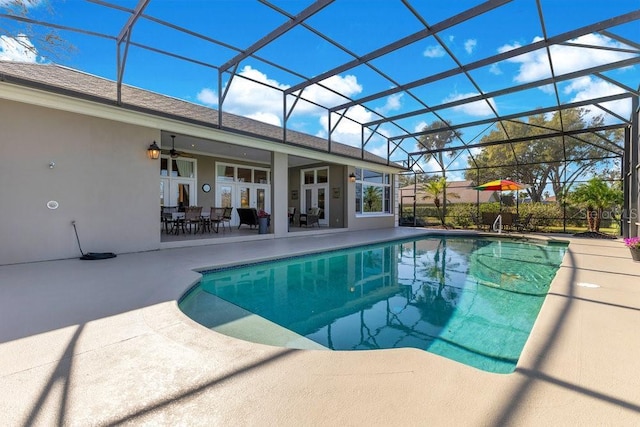 view of pool featuring ceiling fan, glass enclosure, a patio area, and french doors