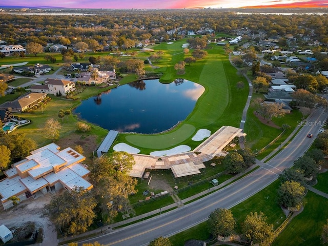 aerial view at dusk featuring a water view