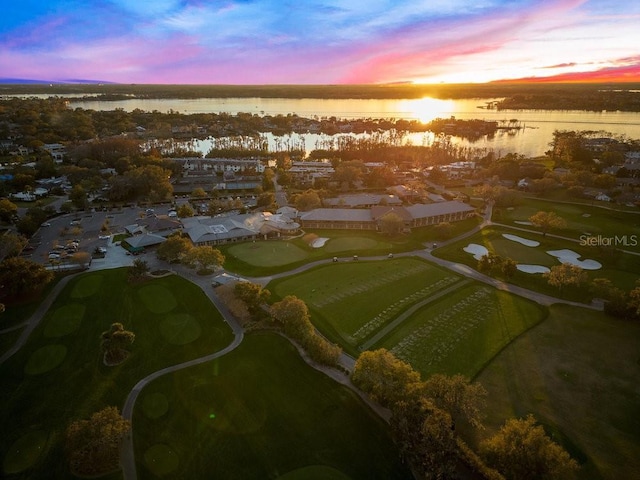 aerial view at dusk featuring a water view