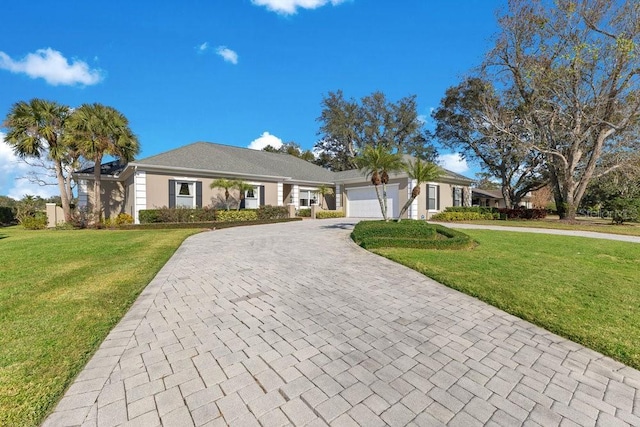 ranch-style home featuring an attached garage, decorative driveway, and a front yard