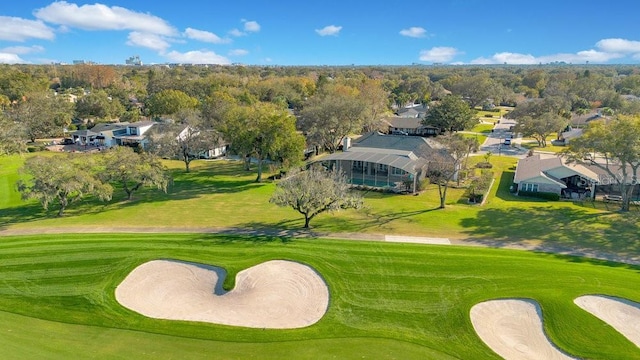 view of property's community with view of golf course and a yard