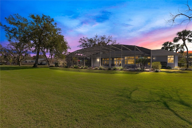 back of house with a lawn and a lanai