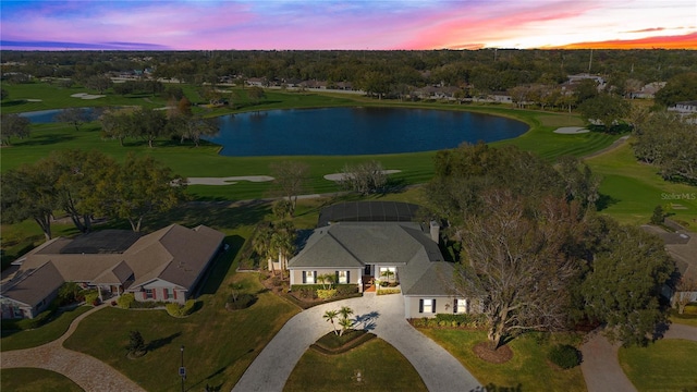 aerial view at dusk featuring a water view