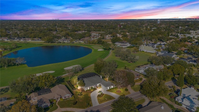 aerial view at dusk featuring a water view and a residential view