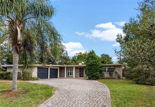 single story home with a garage and a front lawn