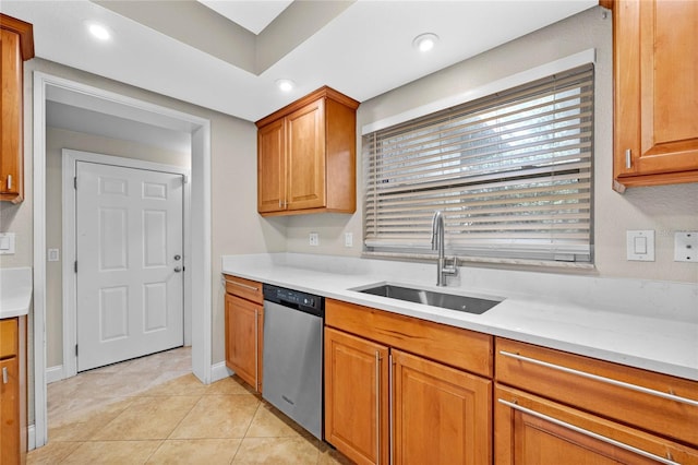 kitchen with light stone counters, stainless steel dishwasher, light tile patterned floors, and sink