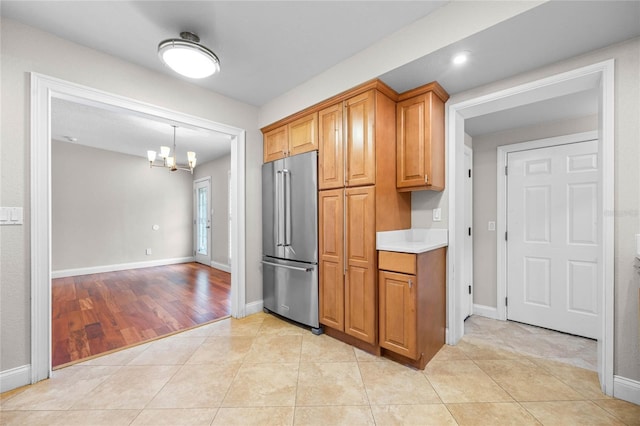 kitchen featuring high end fridge, an inviting chandelier, and light tile patterned flooring