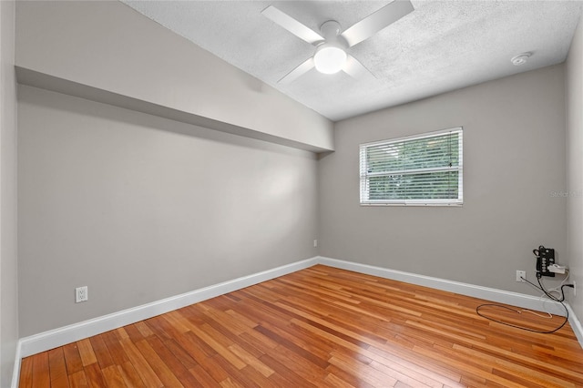 unfurnished room featuring ceiling fan, lofted ceiling, a textured ceiling, and wood-type flooring