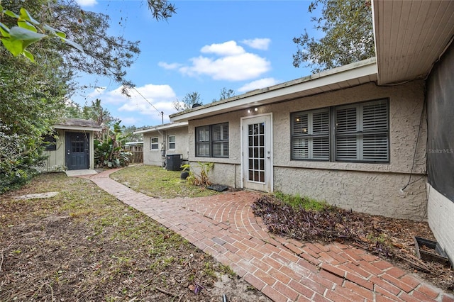 view of exterior entry featuring central AC unit