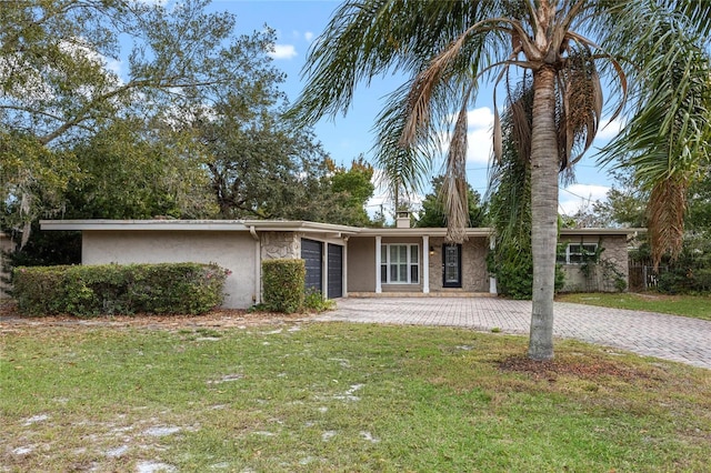 single story home featuring a front lawn