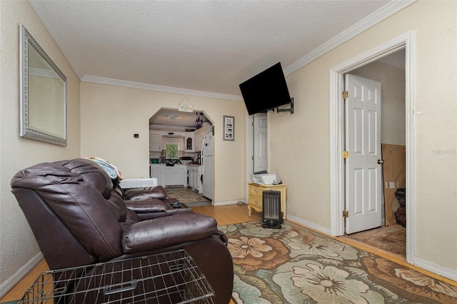 living room with hardwood / wood-style floors, crown molding, and a textured ceiling