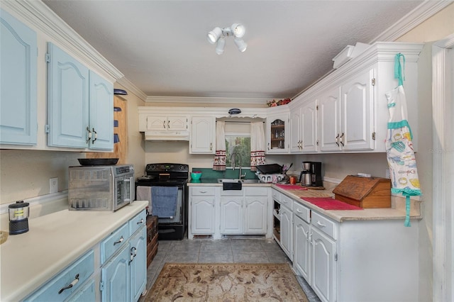 kitchen featuring white cabinetry, black range with electric cooktop, blue cabinetry, sink, and light tile patterned flooring