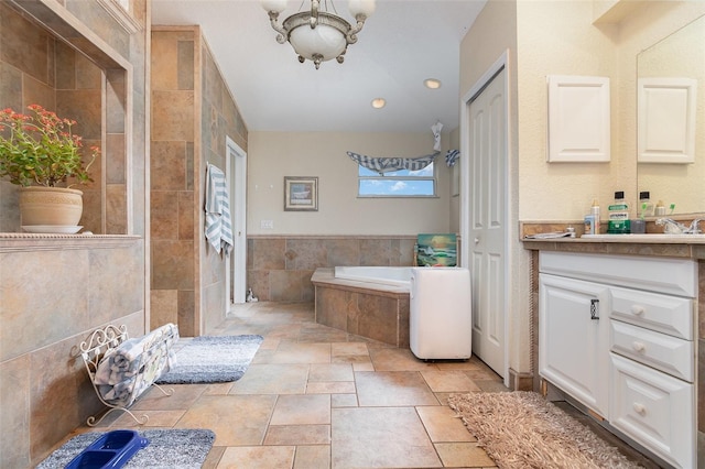 bathroom featuring tile walls, vanity, separate shower and tub, and a notable chandelier