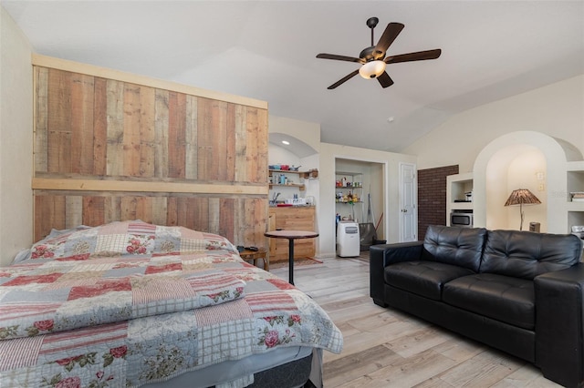 bedroom with ceiling fan, lofted ceiling, and light hardwood / wood-style floors