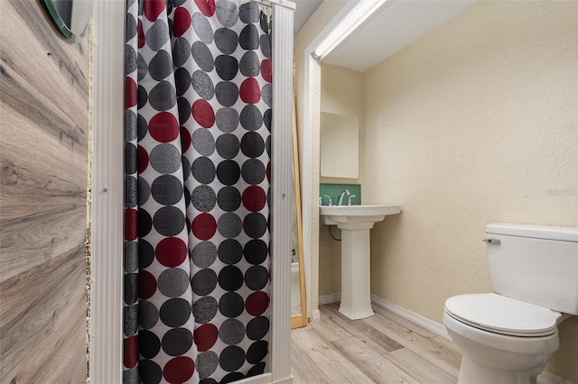 bathroom featuring sink, wood-type flooring, and toilet