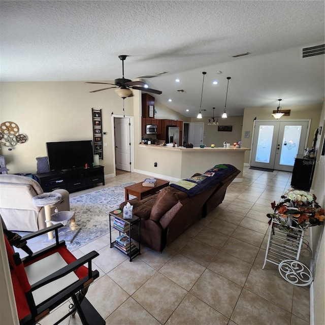 living room featuring light tile patterned floors, ceiling fan, a textured ceiling, vaulted ceiling, and french doors