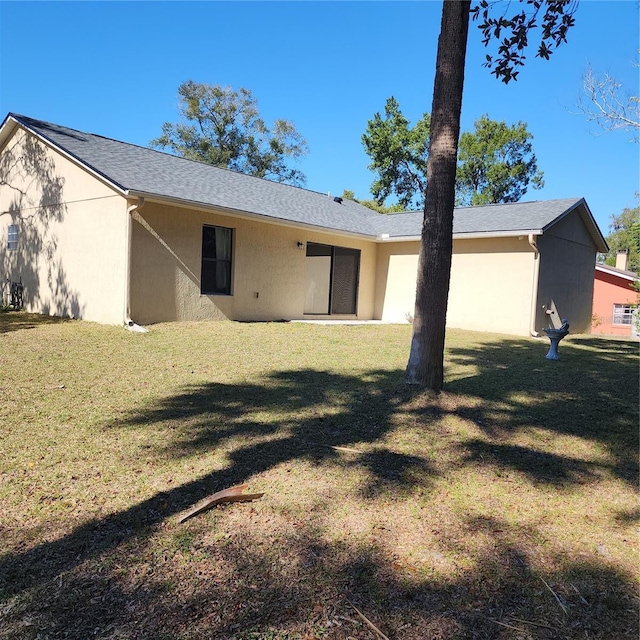 back of property featuring a yard