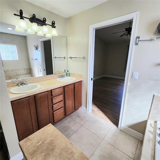 bathroom featuring tile patterned flooring, a bathing tub, vanity, and ceiling fan