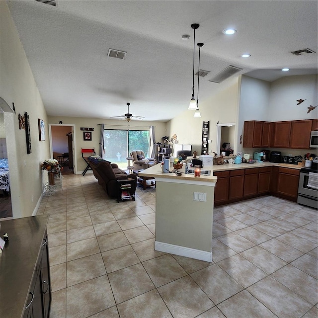 kitchen with pendant lighting, light tile patterned floors, a textured ceiling, and appliances with stainless steel finishes