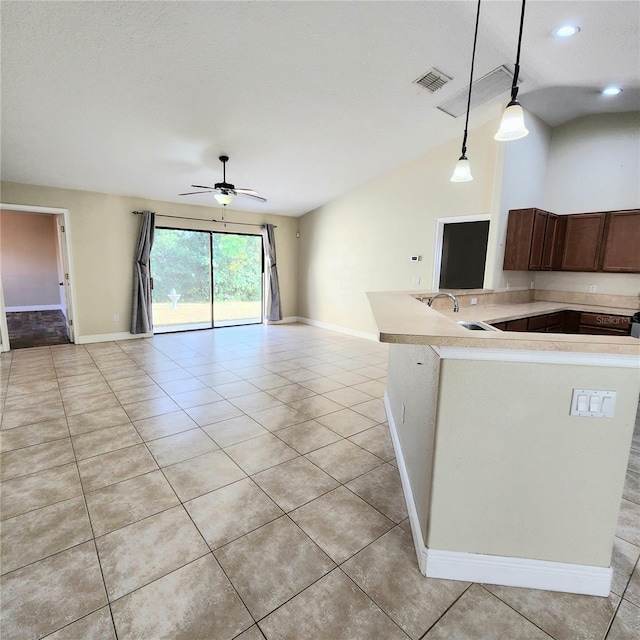 kitchen with sink, ceiling fan, hanging light fixtures, light tile patterned flooring, and vaulted ceiling