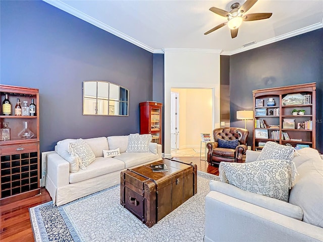 living room featuring ceiling fan, wood-type flooring, and crown molding