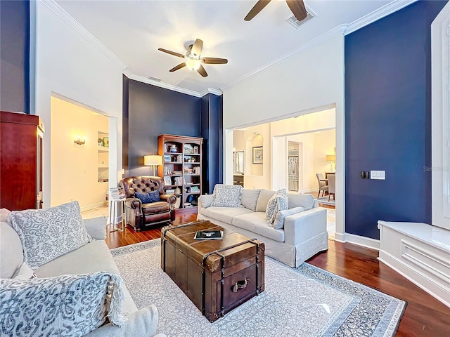 living room featuring ceiling fan, dark hardwood / wood-style flooring, and crown molding