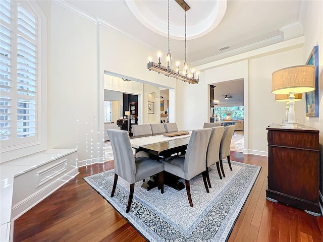 dining room featuring ceiling fan, dark hardwood / wood-style flooring, crown molding, and a tray ceiling