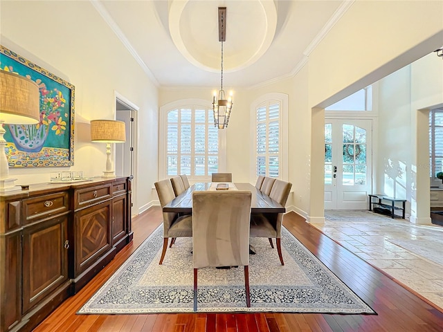 dining space featuring a tray ceiling, a wealth of natural light, hardwood / wood-style floors, and a notable chandelier