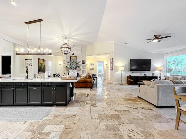 kitchen with sink, hanging light fixtures, crown molding, lofted ceiling, and ceiling fan with notable chandelier