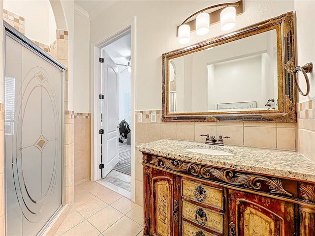 bathroom with vanity, ceiling fan, tile walls, tile patterned flooring, and a shower with shower door