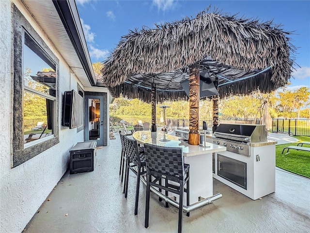 view of patio featuring exterior bar, an outdoor kitchen, and area for grilling