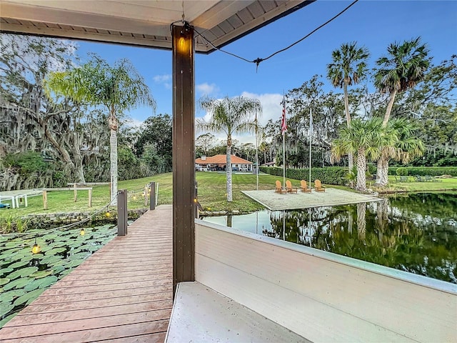 dock area with a lawn and a water view