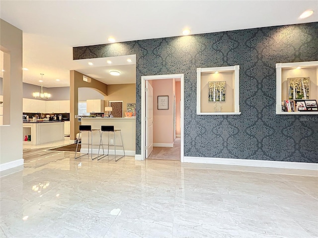 unfurnished room featuring a chandelier