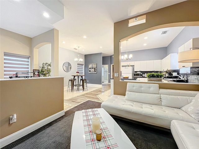 living room featuring carpet flooring and an inviting chandelier