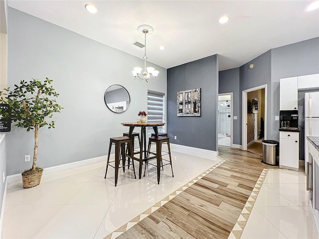 tiled dining space featuring a notable chandelier