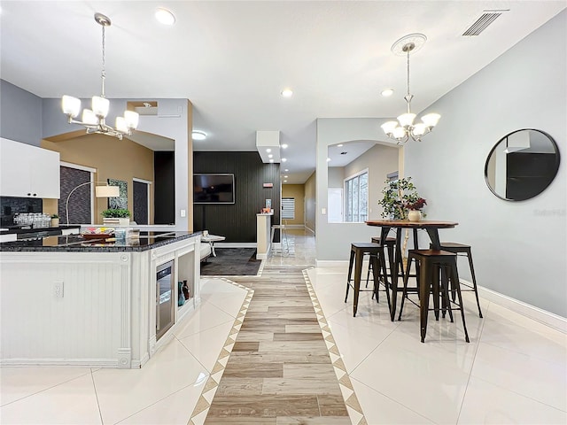 kitchen featuring white cabinetry, pendant lighting, and a notable chandelier