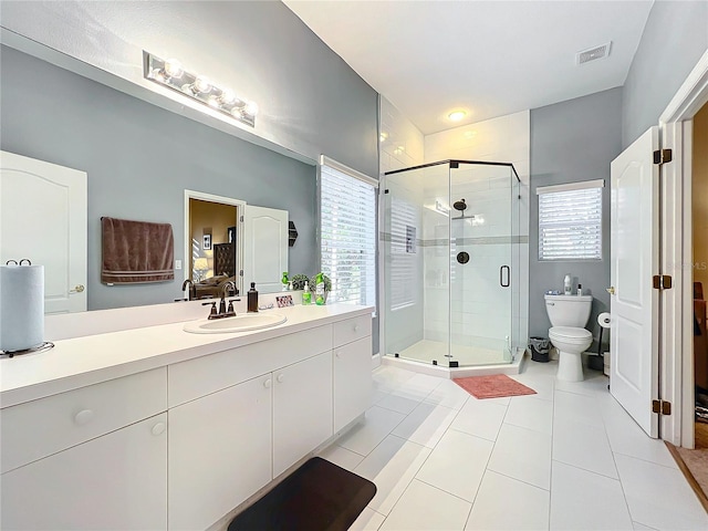 bathroom featuring an enclosed shower, vanity, toilet, and a wealth of natural light