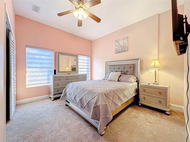 carpeted bedroom with multiple windows and ceiling fan