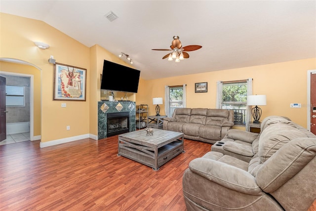 living room with ceiling fan, vaulted ceiling, and wood-type flooring