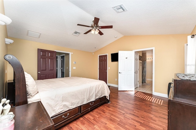 bedroom featuring hardwood / wood-style floors, ensuite bath, ceiling fan, and vaulted ceiling