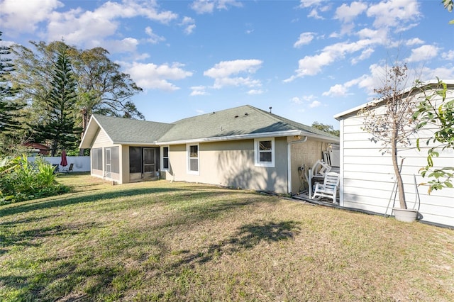 back of property with a lawn and a sunroom