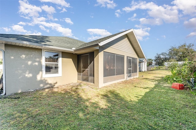 rear view of property featuring a lawn and a sunroom