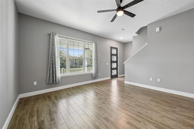 interior space featuring hardwood / wood-style flooring, ceiling fan, and a textured ceiling