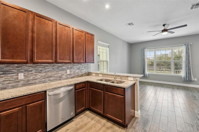 kitchen with decorative backsplash, kitchen peninsula, ceiling fan, sink, and dishwasher