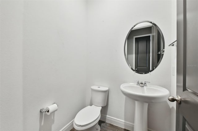 bathroom featuring hardwood / wood-style flooring and toilet