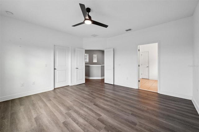 unfurnished bedroom featuring ceiling fan and dark wood-type flooring