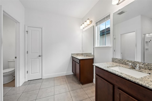 bathroom featuring tile patterned flooring, vanity, an enclosed shower, and toilet