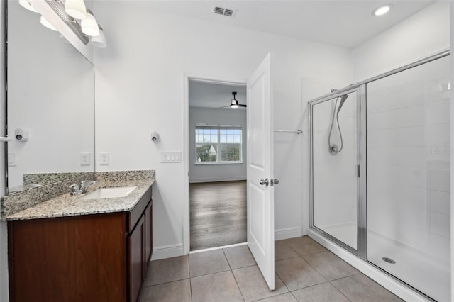 bathroom featuring tile patterned floors, vanity, ceiling fan, and a shower with door